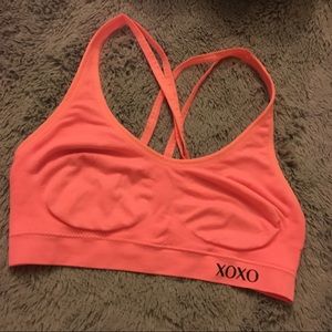 XOXO Coral colored strappy sports bra.