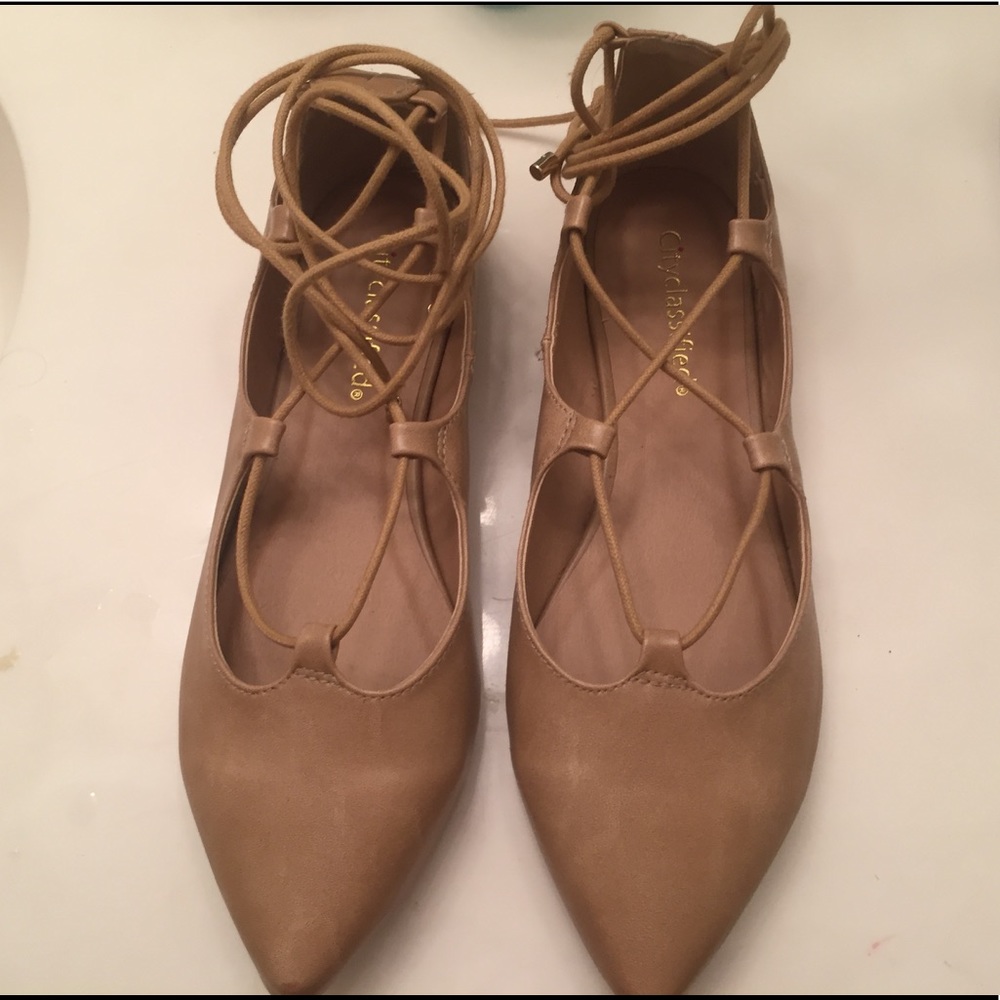 Tan colored pointy, laced up thong flats