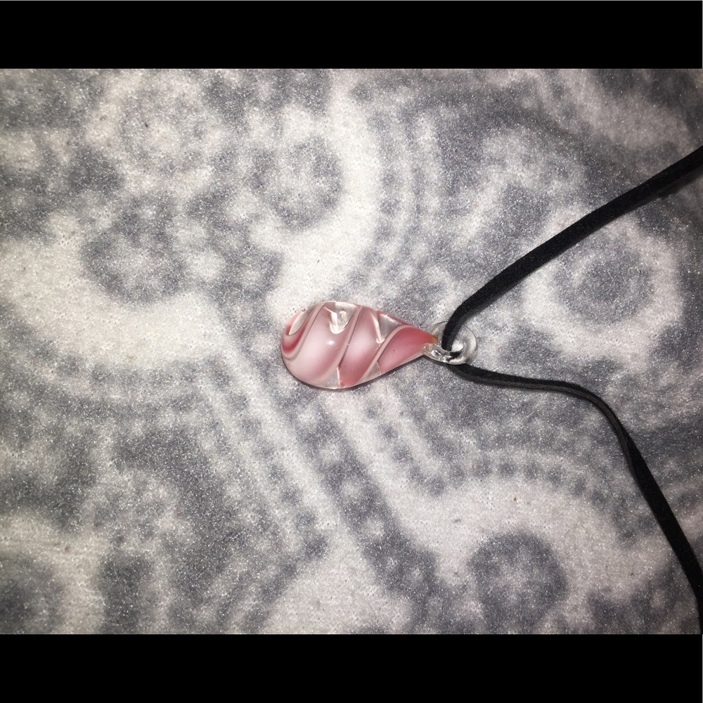 A necklace with a pink and white piece attached