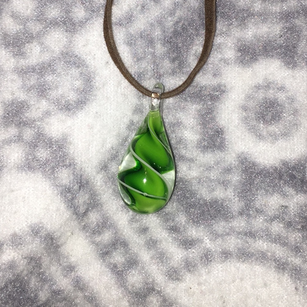 A necklace with green and white piece attached.