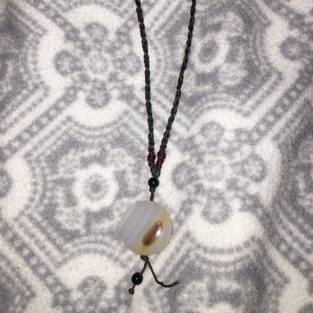 A necklace with a white and brown piece attached
