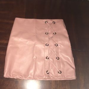 Pink simulated leather skirt with side stitching.