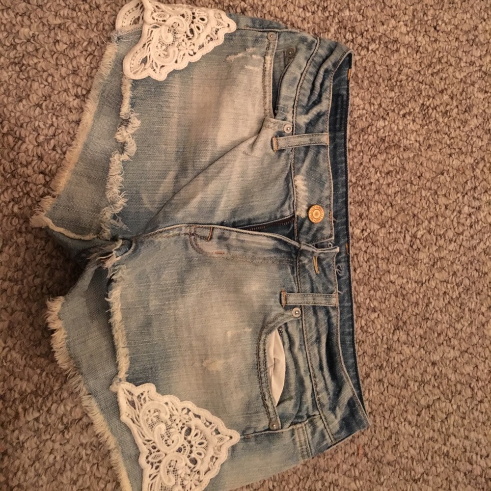Light wash jean shorts. Lace detail on sides.