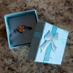 Black metallic and topaz ring