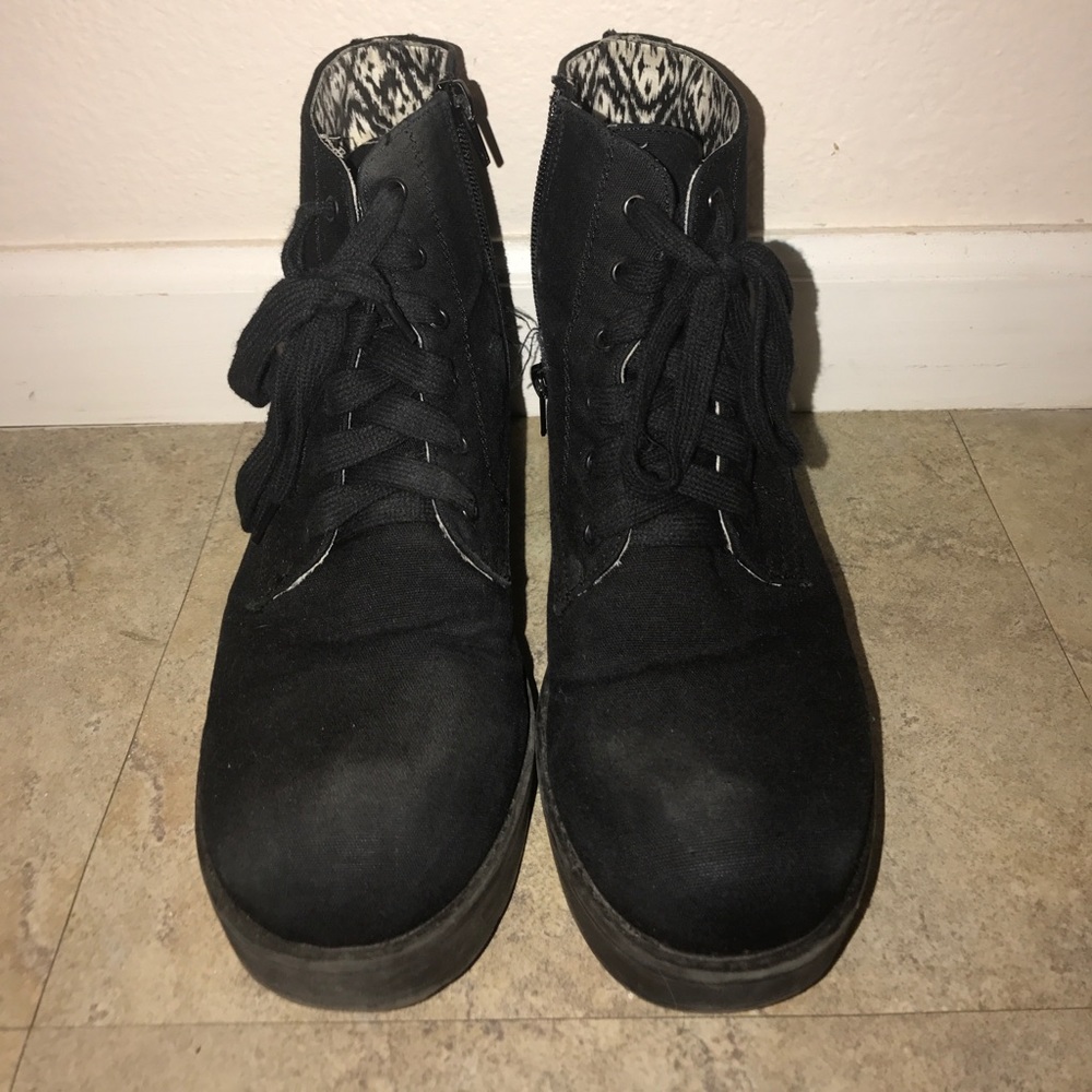 Black combat boot-like sneakers with a platform