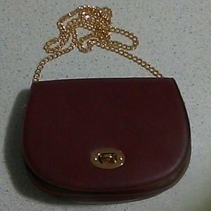 A Burgundy Bag With A Gold scrap