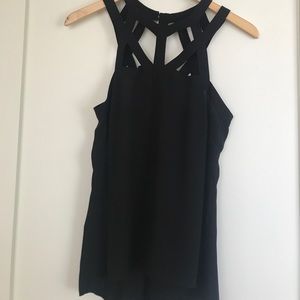 Sleeveless black top with cross high neck detail