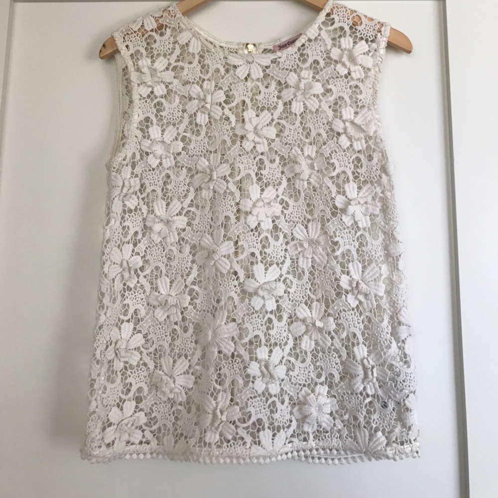 Sleeveless lace top with floral aplecay.