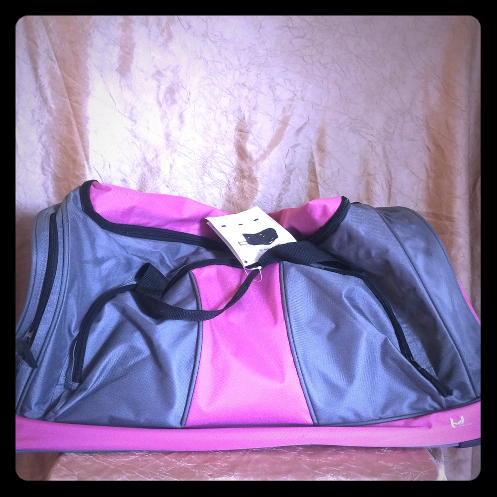 Pink and gray travel bag. With wheels and handle.