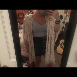 A tan and white poncho sweater
