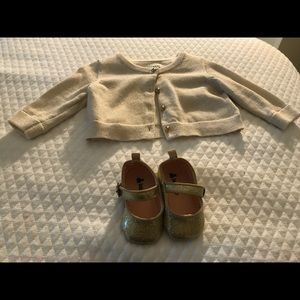 A baby Gap sweater and baby gold shoes