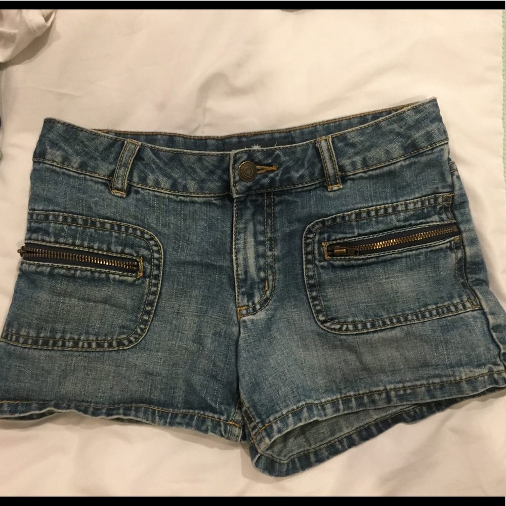 Light blue shorts with zippers on the pockets