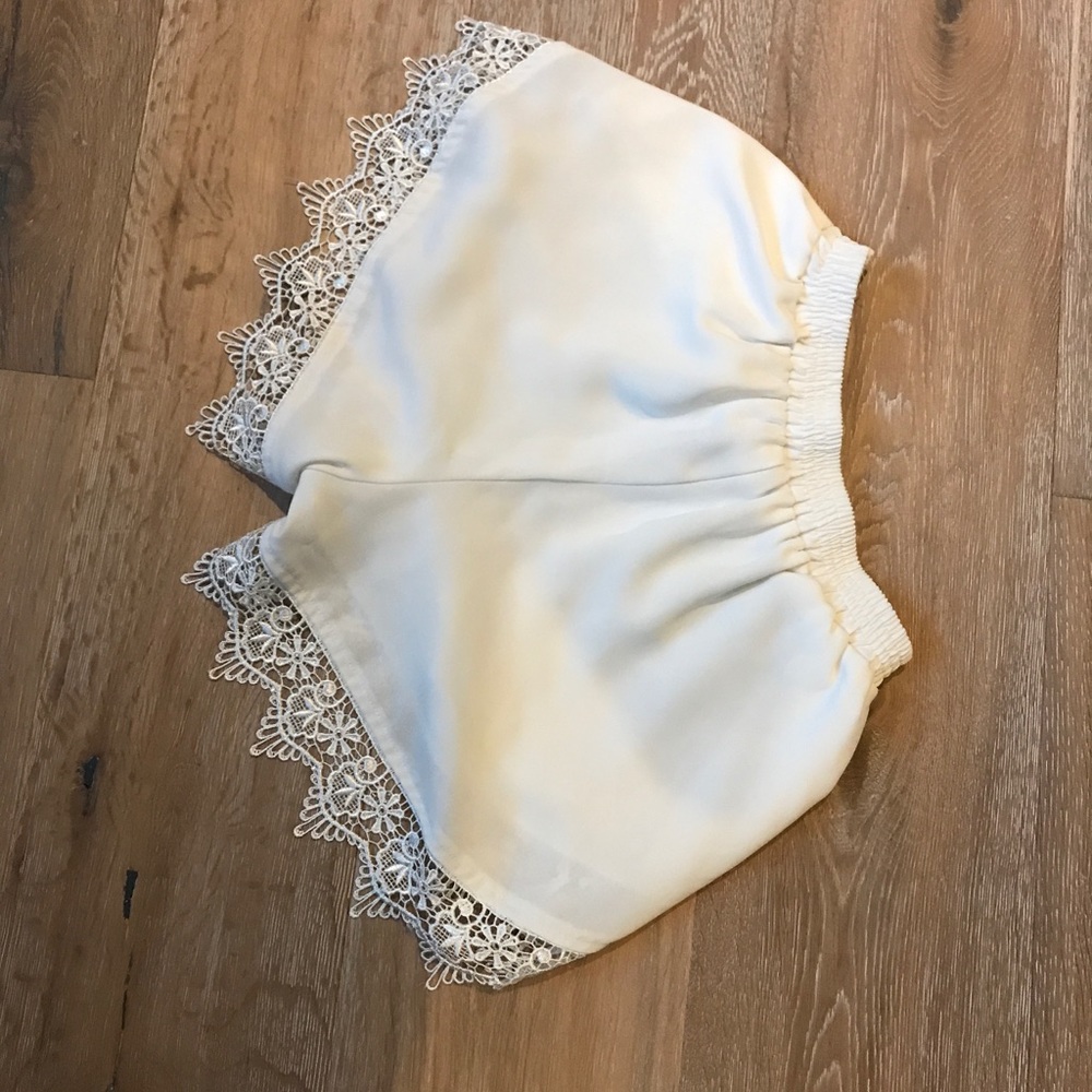 AQUA white shorts with lace detail.