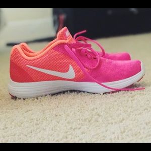 Pink Nike Revolution 3 tennis shoes.