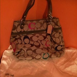 A brown multi colored coach handbag.