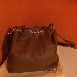 A brown leather Michael Kors handbag.