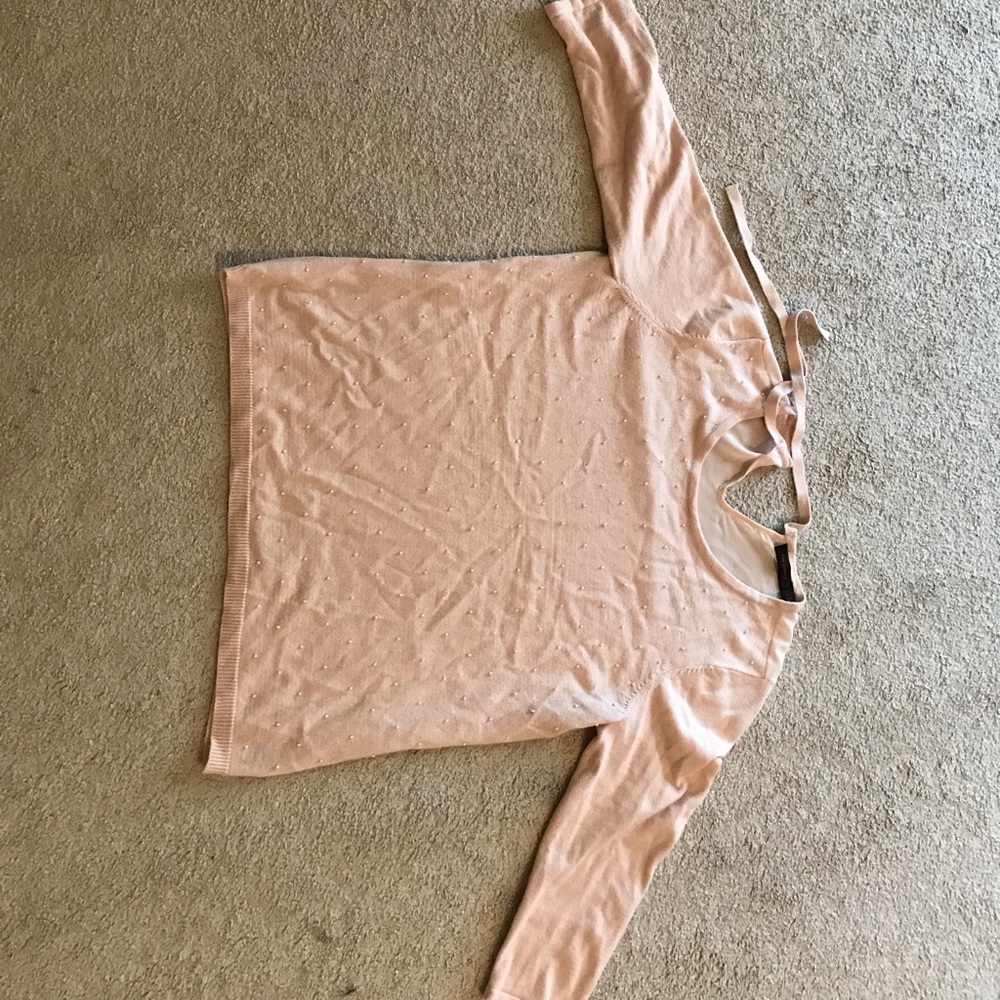 Sweater with pearl-like accents and sheer back.