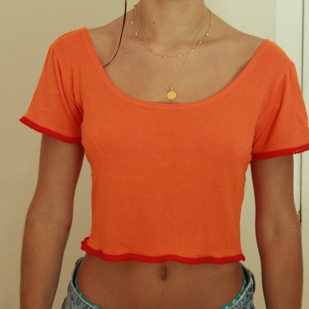 Orange crop top, red pom pom trim