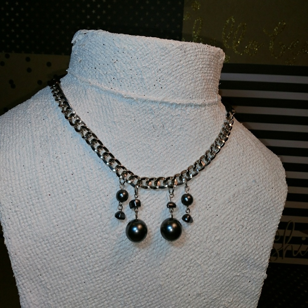 Silver necklace with black dangles.