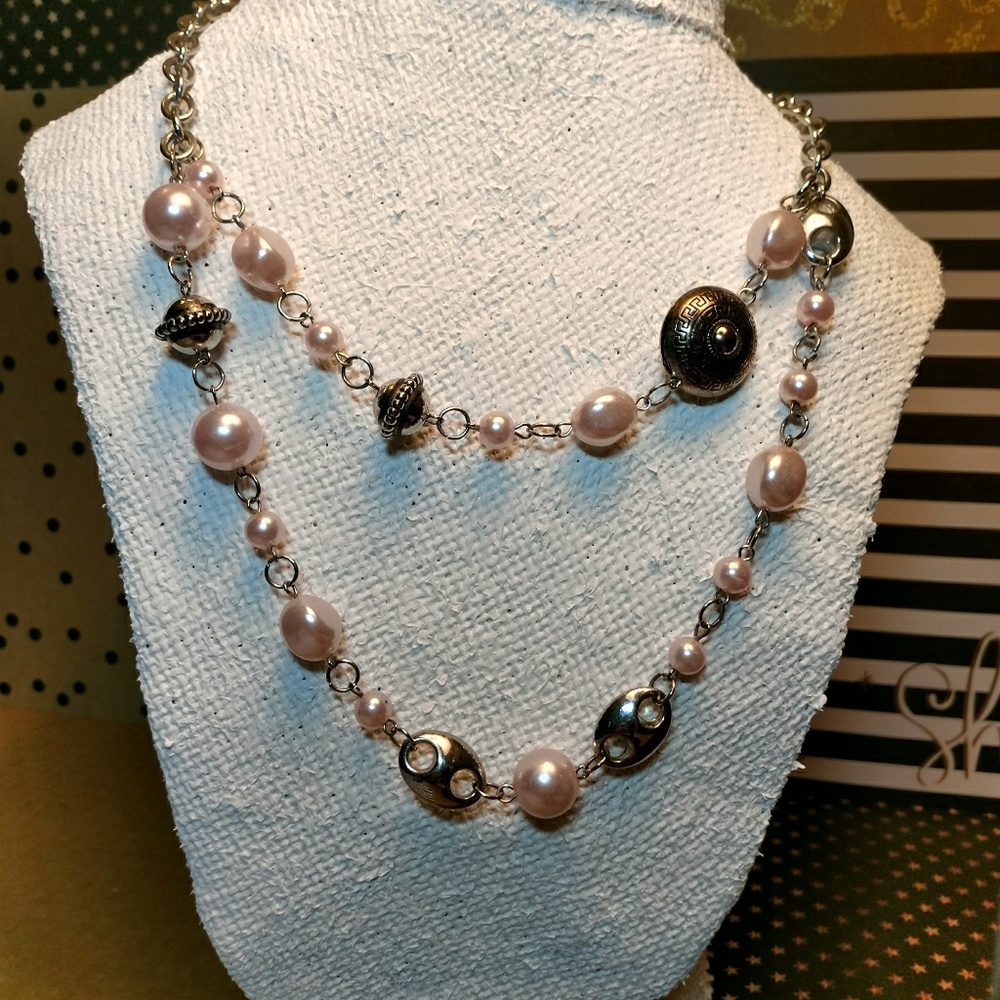 Silver necklace with pink beads.