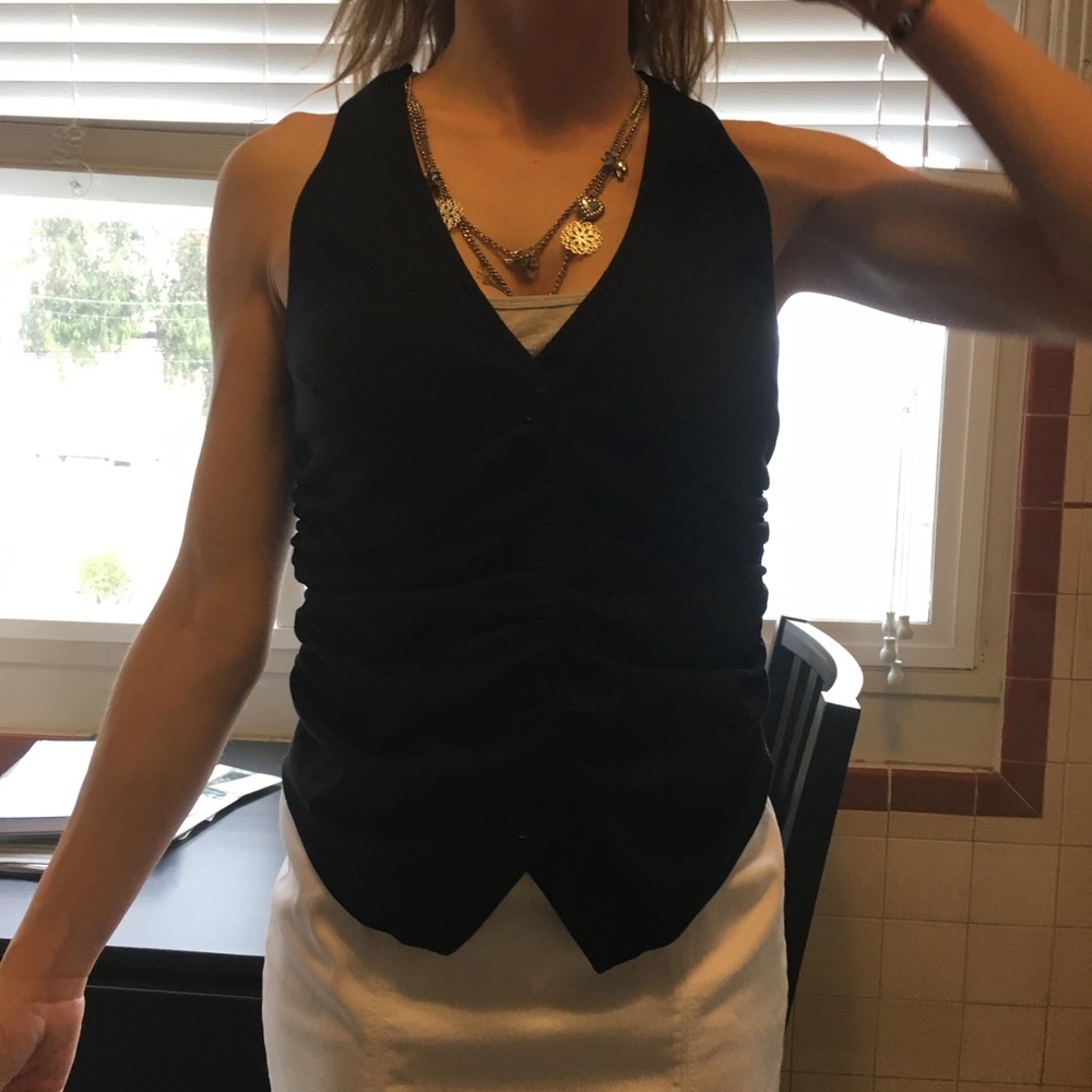 Black vest with ruching and buttons in front.