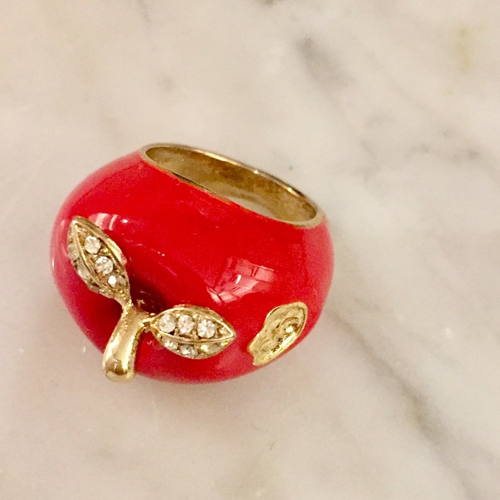 Red apple ring with crystals and logo.
