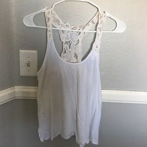 A white tank top with tan crochet detailing