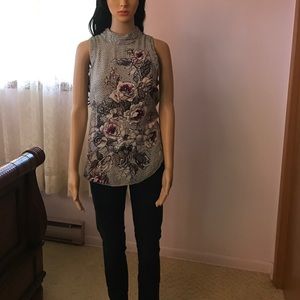 High neck, sleeveless floral top.