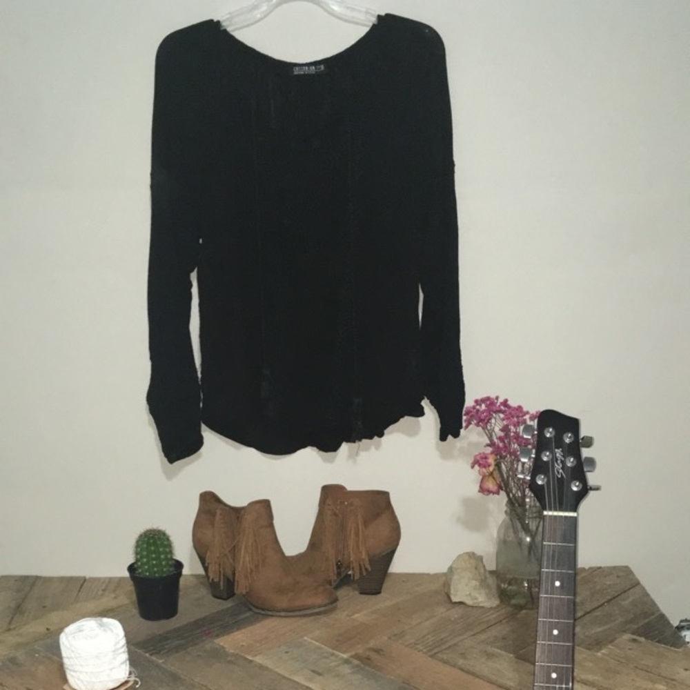 Boho shirt with detailed stitching and tassels .