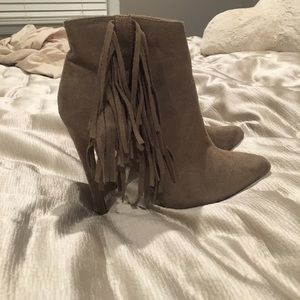 Taupe high-heeled fringed booties.
