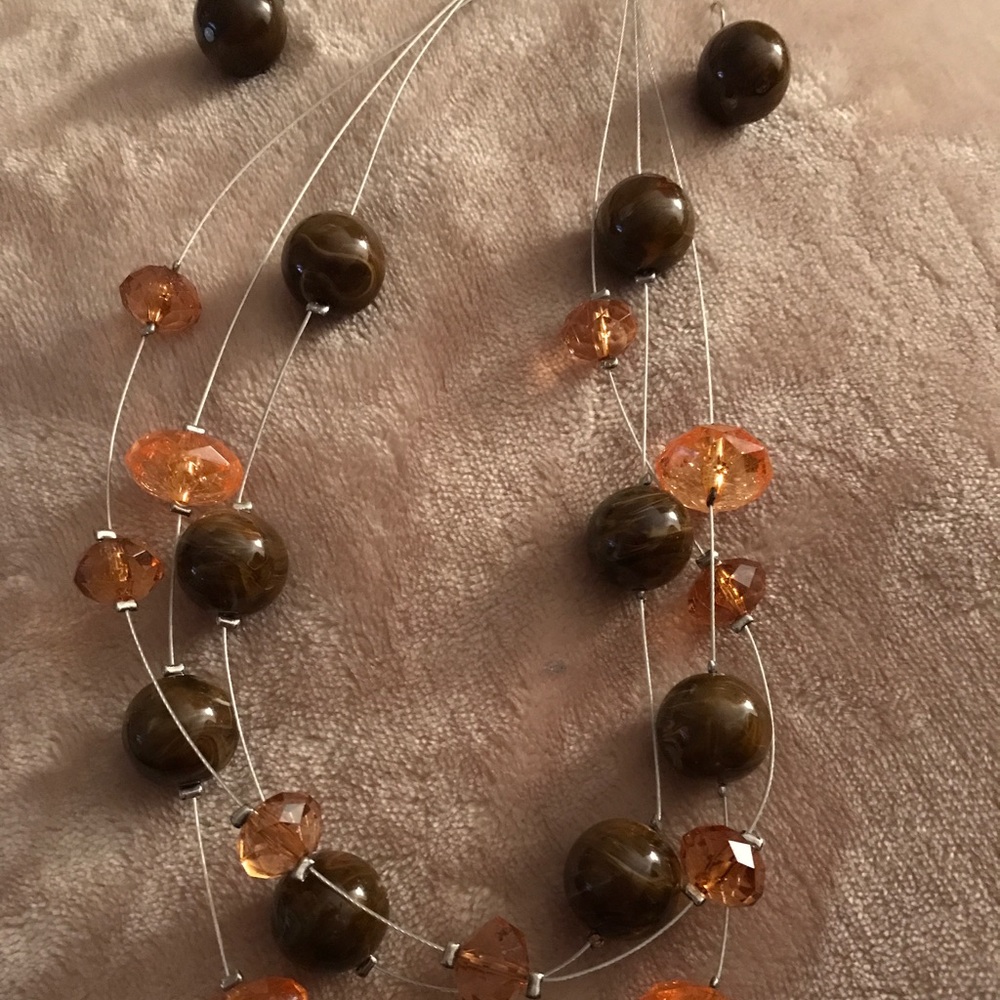 Brown and orangish necklace with brown earrings.