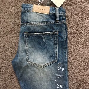 Men's MNML ripped tapered ankle zip jeans.