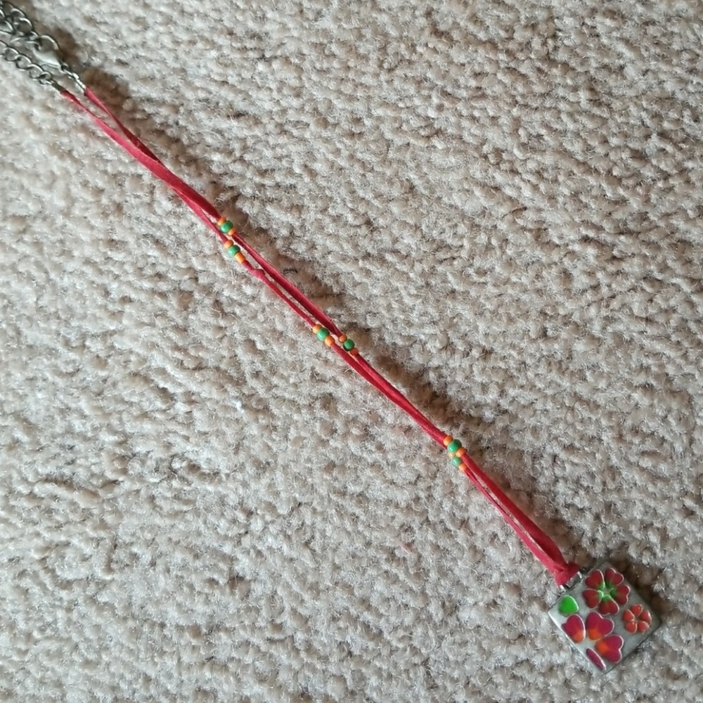 Red fabric necklace with metal and glass pendant
