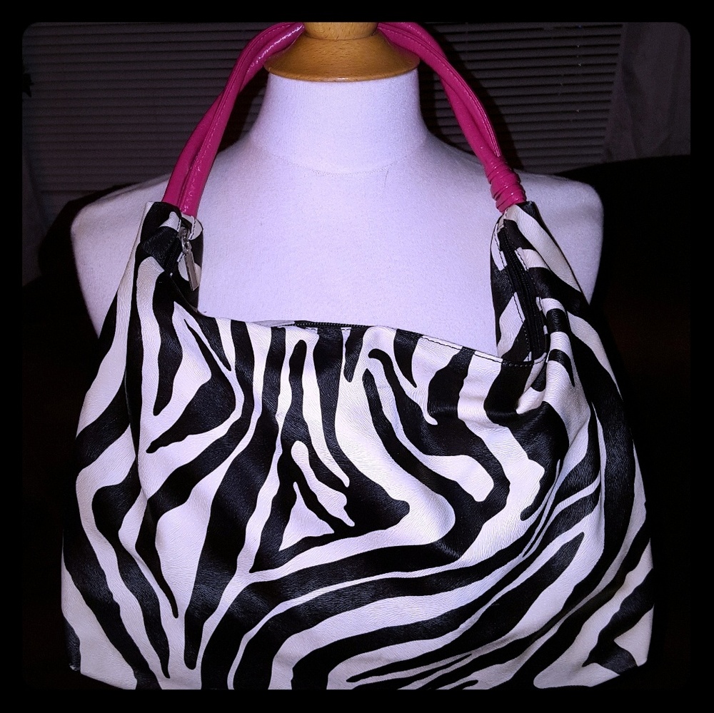 Zebra print hand bag with pink leather handles.
