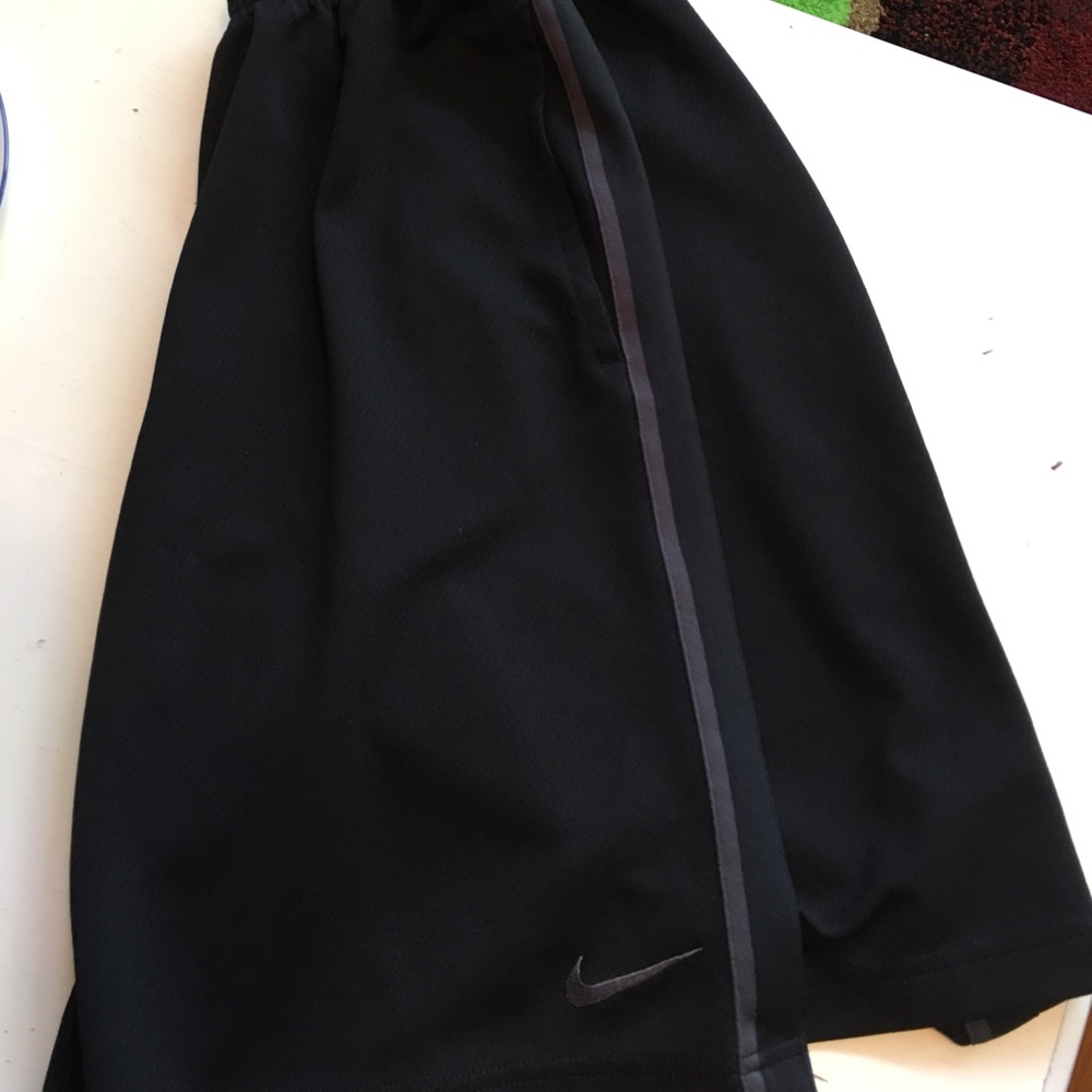 Black Nike shorts with thin grey stripe.