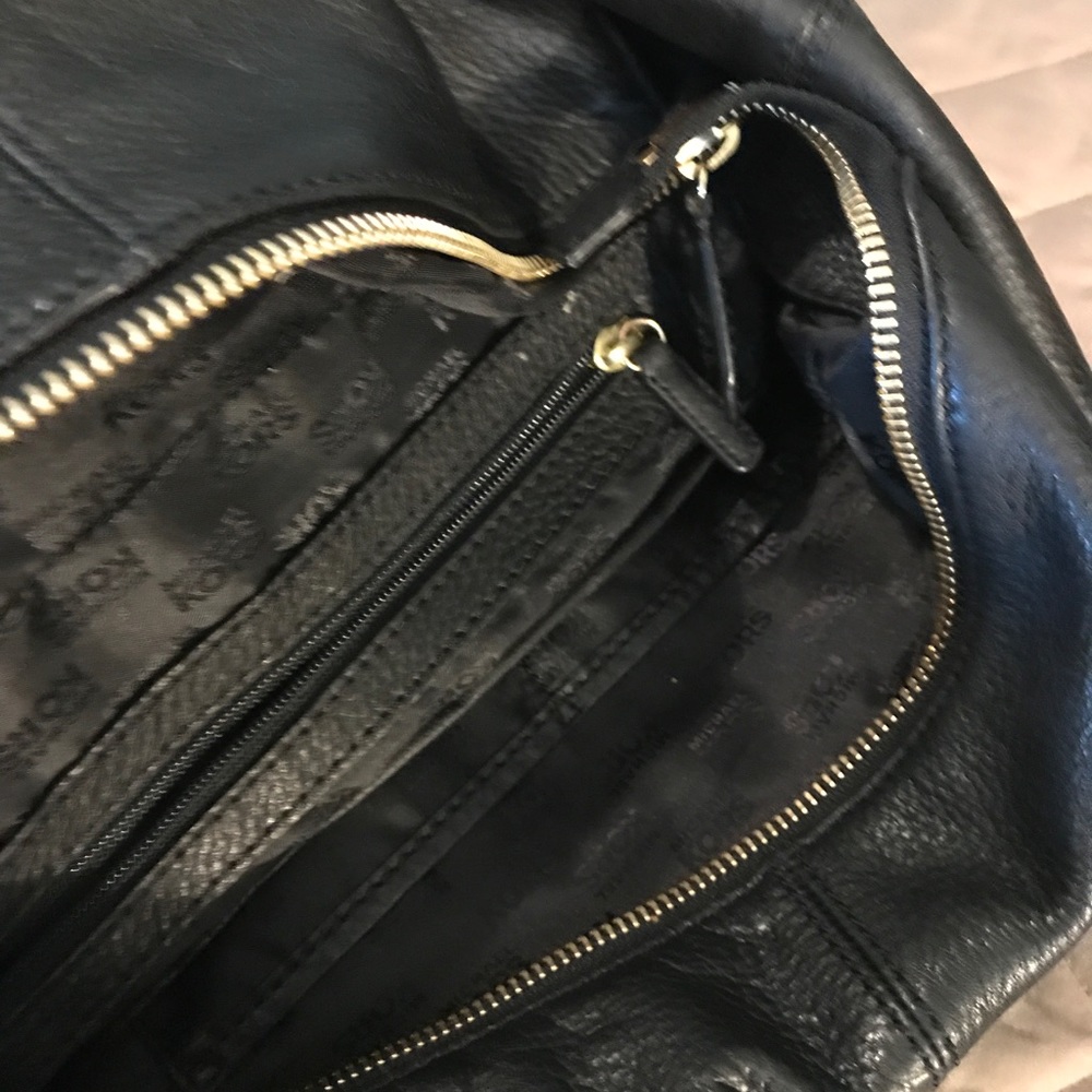 A black Micheal Kors handbag in used condition.