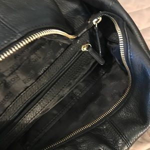 A black Micheal Kors handbag in used condition.