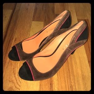 Brown suede shoes with red and black accents.