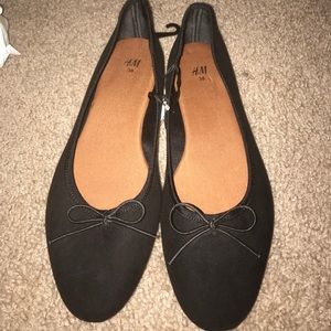 Black flats with bow tie accent.