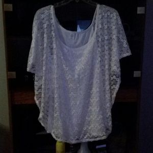A silky tank top with a covering of outside lace