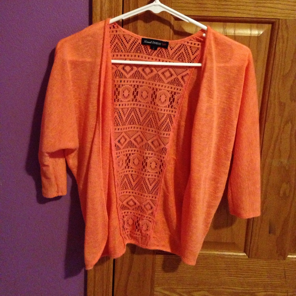 Orange colored sweater with lace in the back.