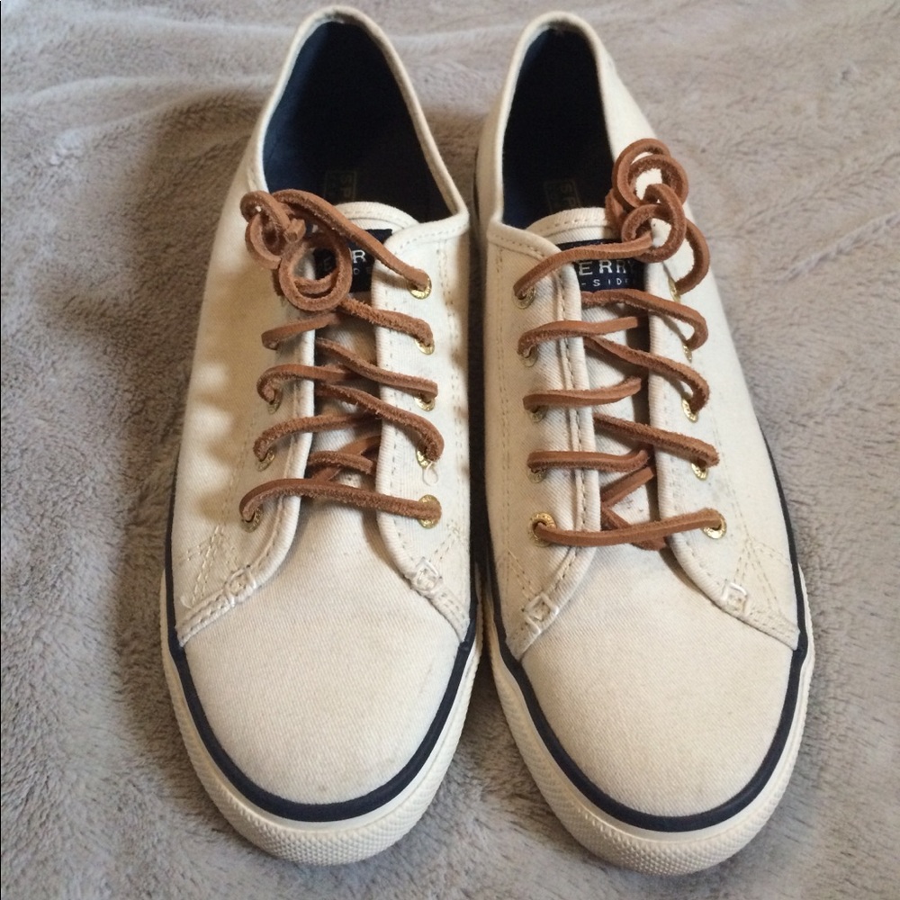 White, blue lined sneakers with brown shoelaces
