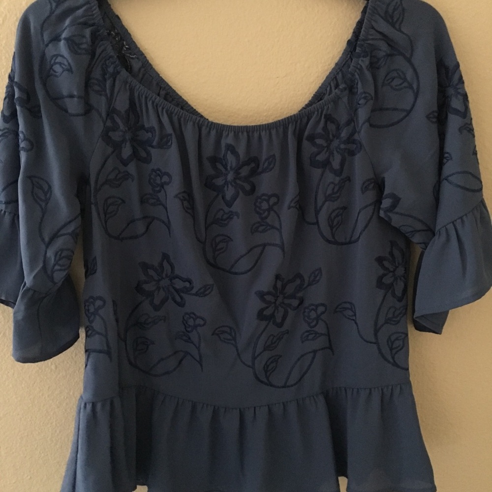 Blue peplum shirt with floral design.