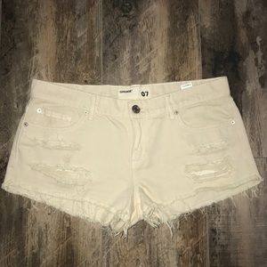 Cream colored ripped festival denim shorts