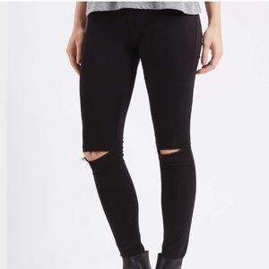 Mid-rise black jeans with rips in the knees
