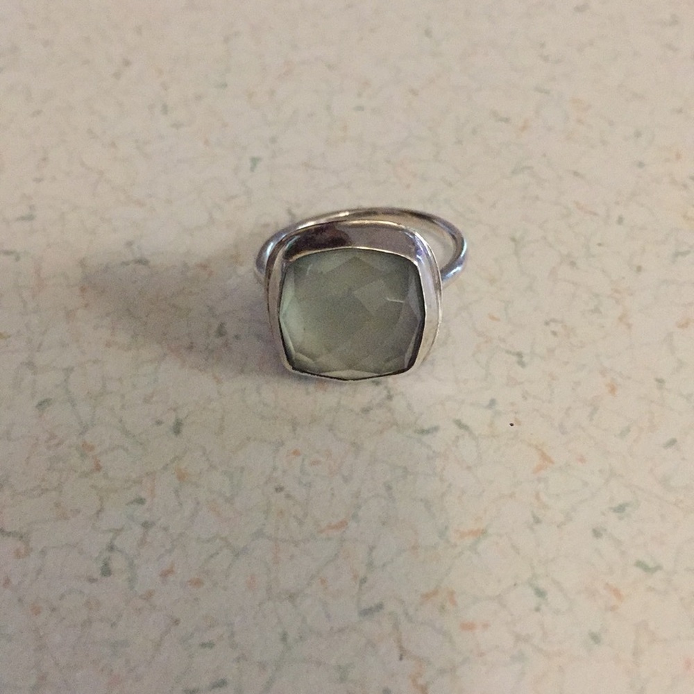 Sterling silver ring with a light green stone.