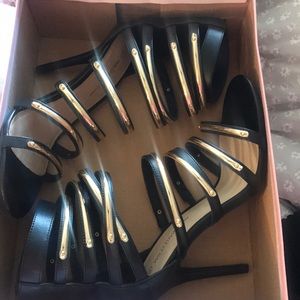 Black heels with gold medal straps