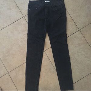 Black jeans with black flower detail.