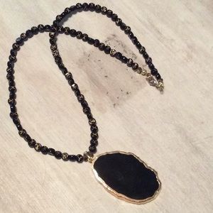 Black and gold colored necklace.