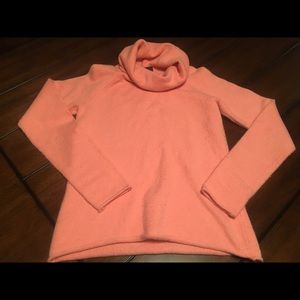 Slightly worn coral sweater with a cowl neck.